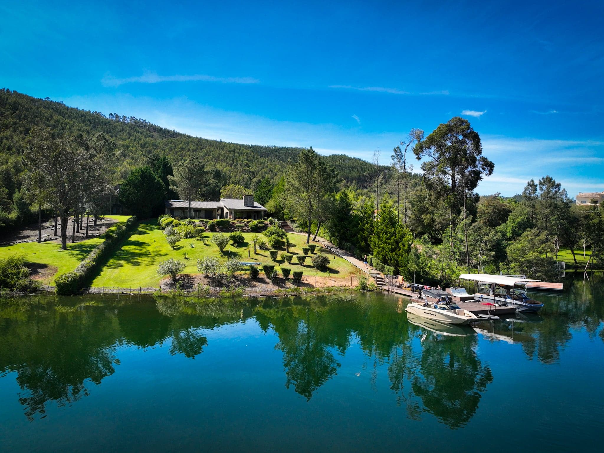 Drone view of the lake house, its garden terraces and the private dock